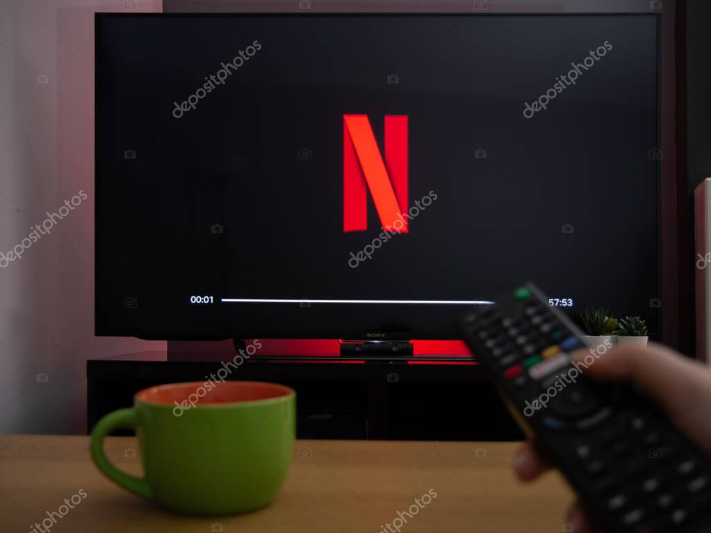 UK, March 2020: TV Television Netflix N logo on screen with remote control