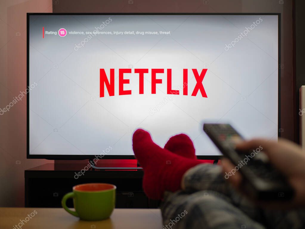 UK, March 2020: TV Television Netflix logo watching with feet up comfy at home
