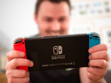 İngiltere, Mart 2020: Nintendo Switch oyun konsolu mutlu oyuncu oyun keyfini çıkarıyor