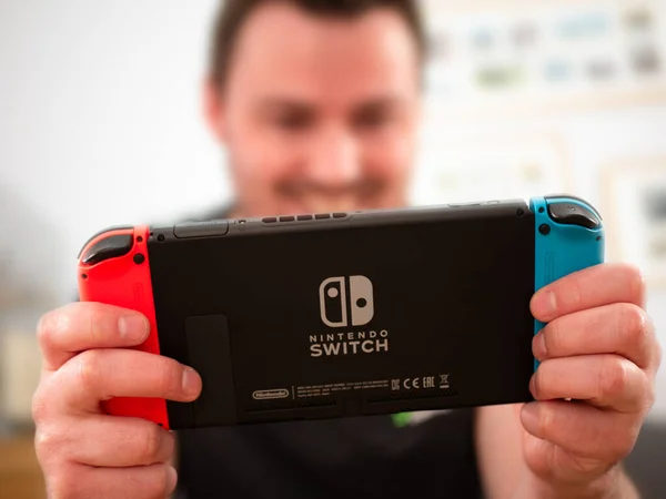 İngiltere, Mart 2020: Nintendo Switch oyun konsolu mutlu oyuncu oyun keyfini çıkarıyor