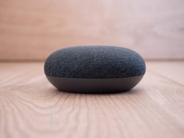 ahşap arka planda ses asistanı ile mini akıllı ev hoparlörü aygıtını kapat