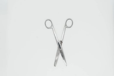 Beyaz arka planda yakın plan bir makas. Yukarıdan görüntüle