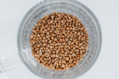 Beyaz arka planda şeffaf bir camda karabuğday. Yukarıdan görüntüle