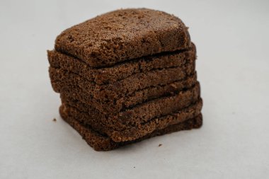 Beyaz arka planda yakın plan çekimde bir parça ekmek. Yan görünüm