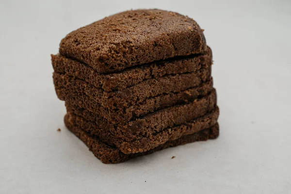 Beyaz arka planda yakın plan çekimde bir parça ekmek. Yan görünüm