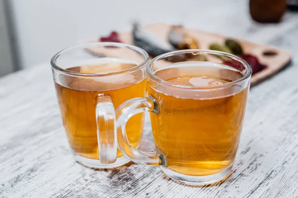 İki bardak bira. Arka planda atıştırmalıklar var. Yan görünüm