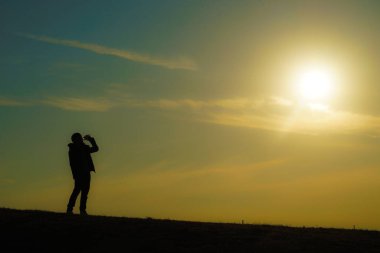 Tepenin alacakaranlığında su içen adamlar