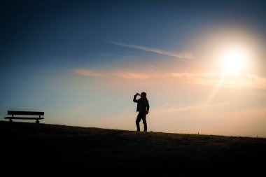 Tepenin alacakaranlığında su içen adamlar