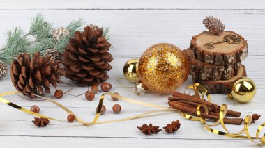 Kırmızı Noel mumunun Noel kompozisyonu, top, çan, anason, fındık ve kozalaklı çam ağacı dalı.