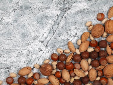 Gri taş arka planda çiğ kabuklu fındık karışımı