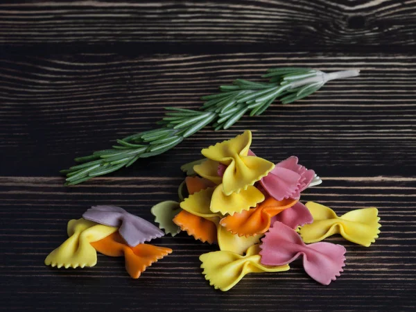 Suche kolorowe włoski makaron farfalle lub łuki z rozmarynu — Zdjęcie stockowe