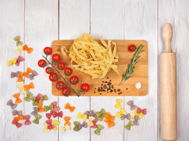 Kuru İtalyan makarnası fettuccini ve domatesli farfalle, biberiye, biber, merdane ve ekmek karışımı.