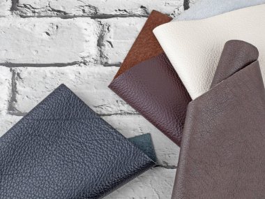 Gri tuğla arkaplanda farklı renkler doğal deri dokusu örnekleri