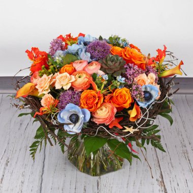 Güllerle, şakayıklarla ve açık ahşap zeminde leylaklarla çiçek aranjmanı