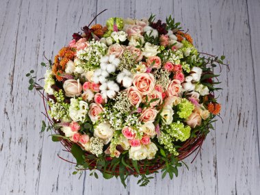 Güllü çiçek aranjmanı, leylak ve ahşap zeminde pamuk.