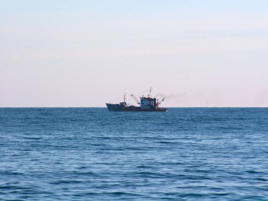 Endüstriyel gemi mavi denizde yol alıyor.