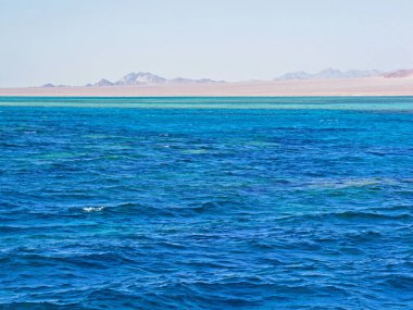 Deniz yüzeyinde parlak mavi dalgalar