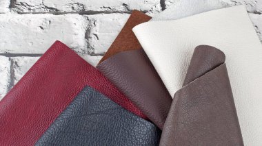 Gri tuğla arkaplanda farklı renkler doğal deri dokusu örnekleri