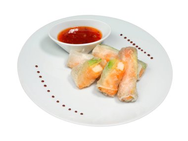 Taze pirinç un rulolarını karides ve avokado ile kapatın. Beyaz arka planda izole edilmiş yuvarlak tabakta bir kase soslu lezzetli Japon yemeği.