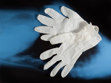 Bir çift lateks tıbbi eldiven ve mavi X-ray görüntü arkaplanı. Koruma kavramı