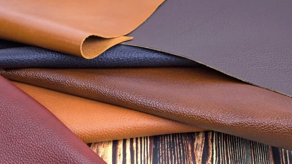 深色木制背景的不同颜色天然皮革纹理样品 — 图库照片