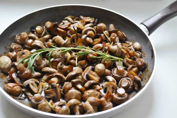 Roasted mushrooms with rosemary and garlic in a pan over white background — Stock Photo, Image