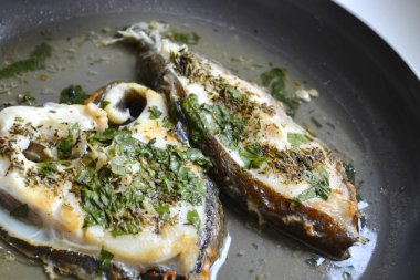 Kavurma alabalık biftek maydanoz ve diğer otlar beyaz bir arka plan üzerinde bir Pan ile