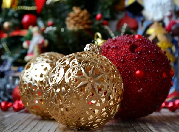 Bola dorada con otras decoraciones y juguetes de Navidad rojos y verdes — Foto de Stock