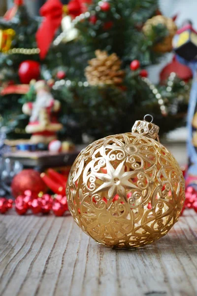 Zlatý míč s dalšími červené a zelené vánoční dekorace a hračky — Stock fotografie