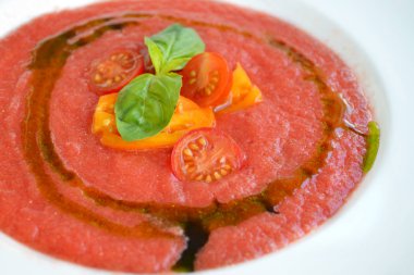 Kiraz domates ve otlar beyaz plaka ile soğuk kırmızı domates gazpacho çorbası