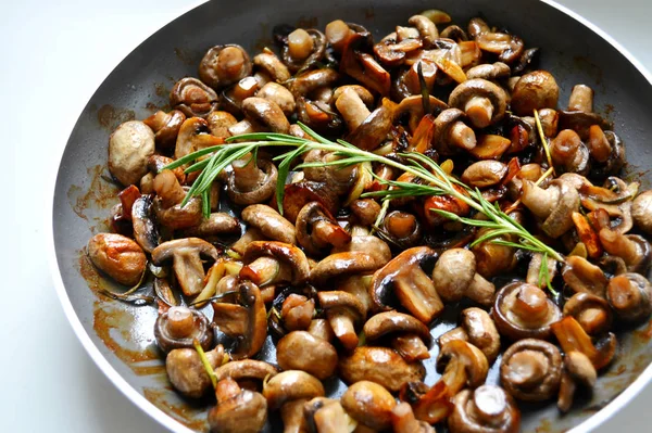 Roasted mushrooms with rosemary and garlic in a pan over white background — Stock Photo, Image