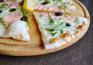 Somon, limon ve roka ahşap plaka üzerinde tüm pizza