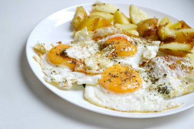 Büyük tabak kızarmış yumurta, patates kızartması ve domates - geleneksel bir kahvaltı dolu yuvarlak