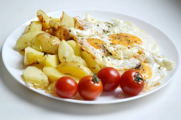 Großer runder Teller voller Spiegeleier, Pommes frites und Kirschtomaten - ein traditionelles kontinentales Frühstück — Stockfoto