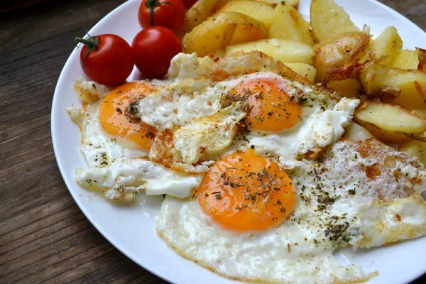 Grande assiette ronde pleine d "œufs frits, de frites et de tomates cerises - un petit déjeuner continental traditionnel — Photo