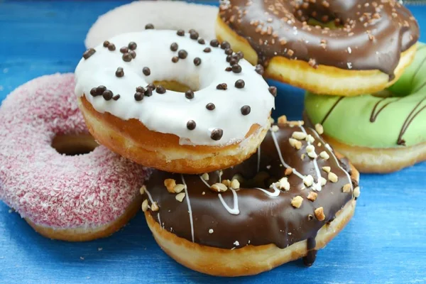 Collection of tasty donuts on blue wooden board — Stock Photo, Image