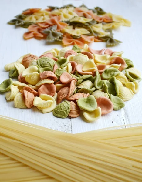 Conjunto de diferentes tipos de massas italianas coloridas na mesa de madeira — Fotografia de Stock