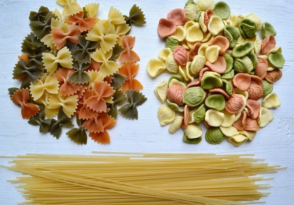 Ensemble de différents types de pâtes italiennes colorées sur table en bois — Photo