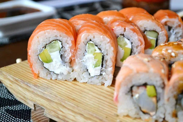Heerlijke broodjes en sushi met paling, zalm en crème kaas — Stockfoto