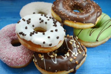 Mavi ahşap tahta üzerinde lezzetli donuts topluluğu