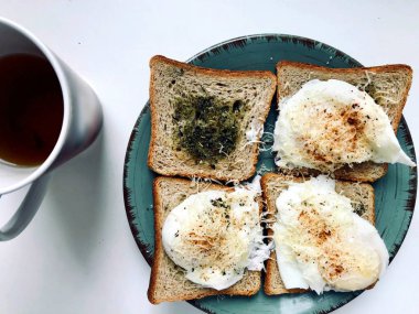 Lezzetli İngiliz kahvaltısı tost otlar ile yapılan ve Parmesan peyniri ve biber ile Benedict yumurta haşlanmış