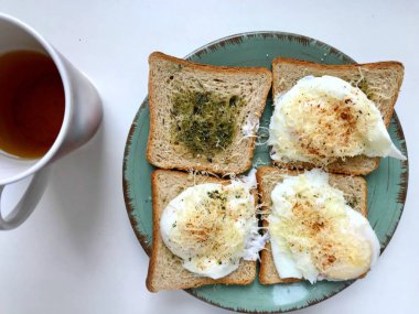 Lezzetli İngiliz kahvaltısı tost otlar ile yapılan ve Parmesan peyniri ve biber ile Benedict yumurta haşlanmış