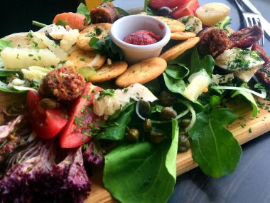 Akdeniz tabağı aperatifler, otlar, peynir, domates ve sos ile