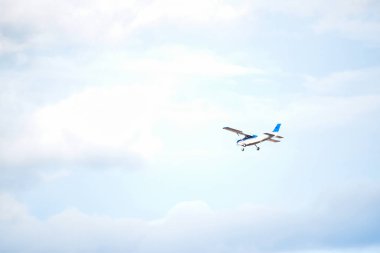 Light plane flying over a little cloudy blue sky
