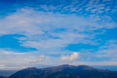 Kümülüs bulutları ve sirrus bulutları dağların üzerinde