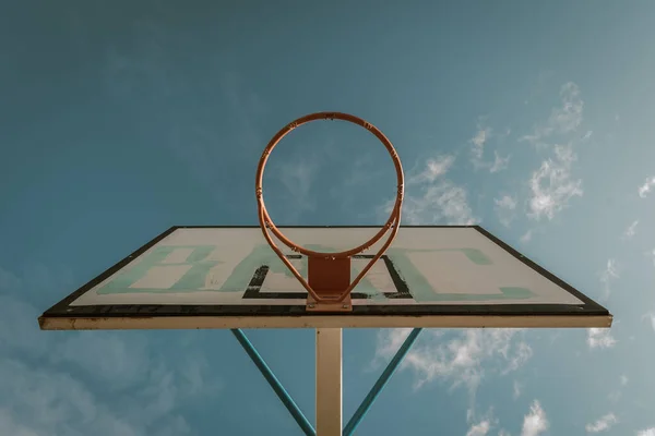 Basketball hoop in a community park waiting for the storm to start with a dramatic sky — Stock Photo, Image