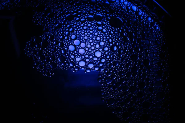 Oljedroppar från en blandning av vatten och olivolja belysta med färgad glödlampa — Stockfoto