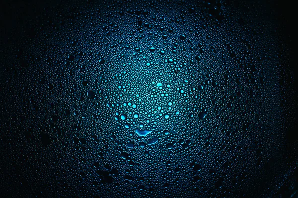 Blue oil droplets from a mixture of water and olive oil illuminated with colored bulb — Stock Photo, Image