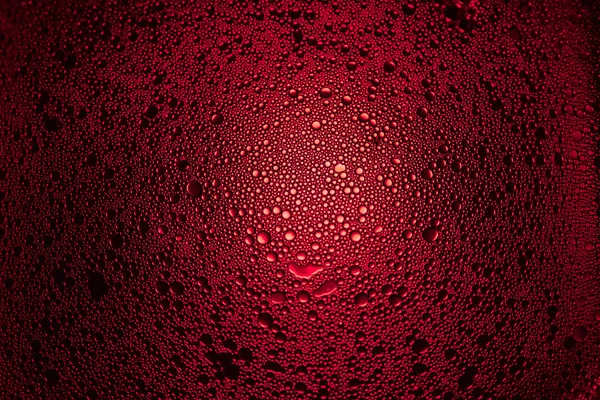 red oil droplets from a mixture of water and olive oil illuminated with red colored bulb