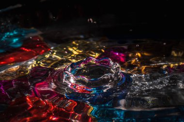 Su damlaları su sıçratarak dalgaları, dalgaları ve soyut su sütunlarını renklendirir.